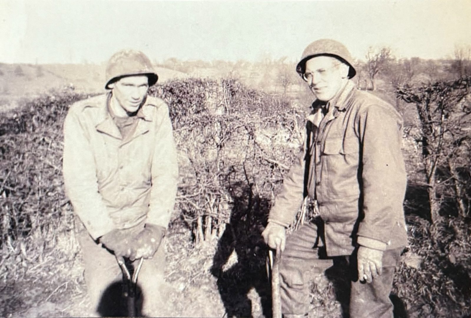 George (left) and another engineer with their tools in bare-tree winter country.